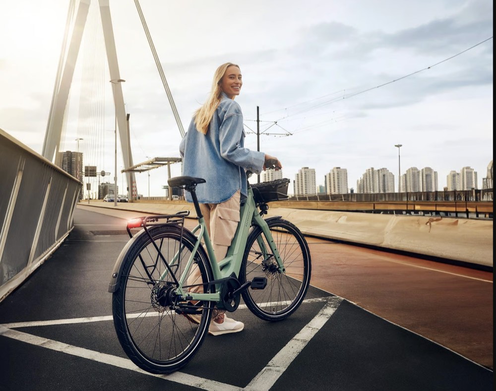 Cycliste avec son vélo électrique sur un pont en ville
