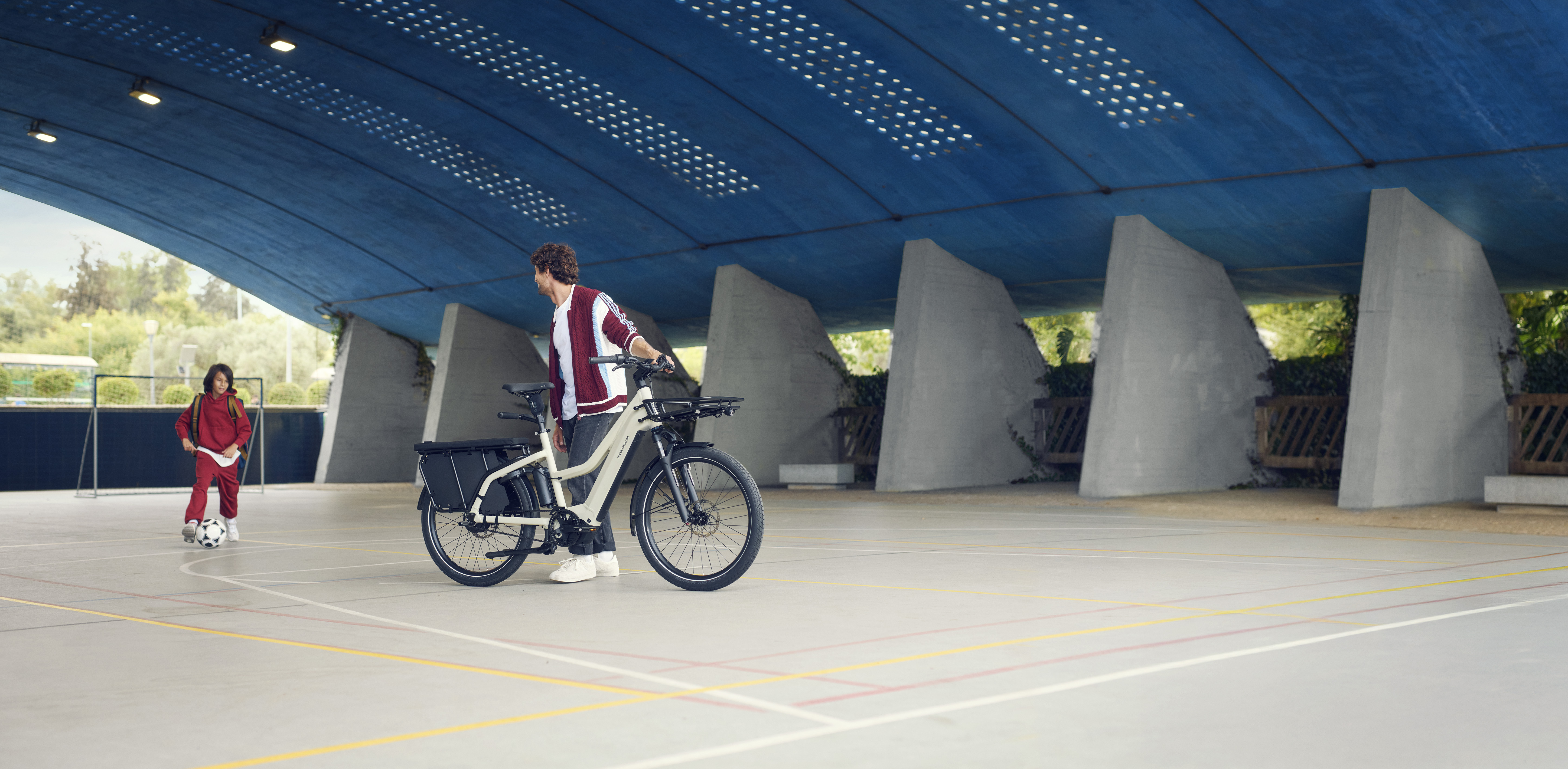 Riese & Müller Multicharger avec un adulte et un enfant sur un terrain de sport